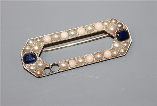 An early 20th century French 18ct white metal, sapphire, split pearl and split coral set octagonal brooch (2 stones missing), 52mm.